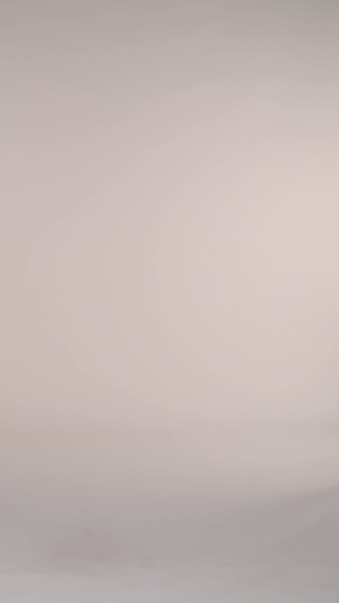 Video of a woman wearing a green and white patterned one piece swimsuit against a white background