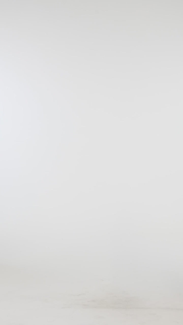 Video of model wearing a black and white striped printed midi cover-up dress featuring over the shoulder straps and a tie front. 