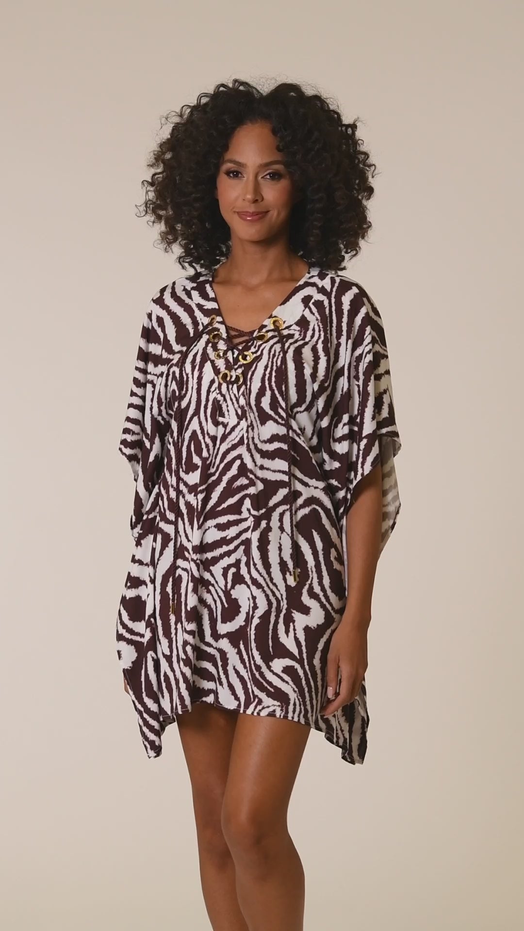 This is a video of a Model is wearing a java colored animal printed v-neck caftan wrap cover up in our Fierce Lines collection!