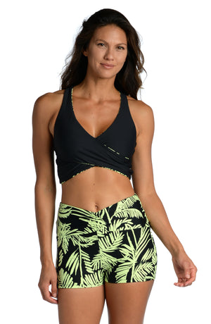 Model is wearing a green and black colored tropical printed mid waist bike short from our Abstract Palm collection!