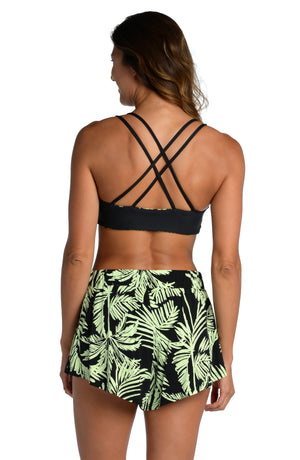 Model is wearing a green and black colored tropical printed flounce short from our Abstract Palm collection!