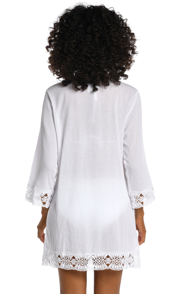 Model is wearing a white v-neck tunic swimsuit cover up from our Island Fare collection.