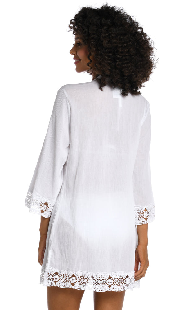Model is wearing a white v-neck tunic swimsuit cover up from our Island Fare collection.