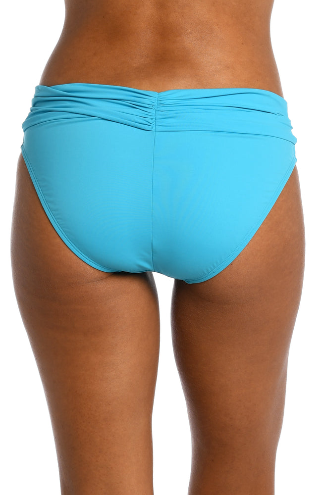 
            
                Load image into Gallery viewer, Model is wearing a azul (light blue) colored shirred hipster swimsuit bottom from our Best-Selling Island Goddess collection.
            
        