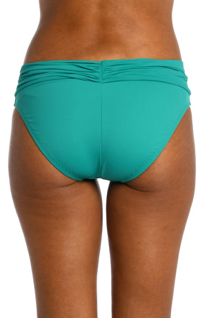 
            
                Load image into Gallery viewer, Model is wearing a emerald colored shirred hipster swimsuit bottom from our Best-Selling Island Goddess collection.
            
        