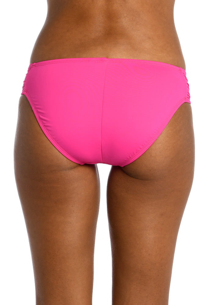 
            
                Load image into Gallery viewer, Model is wearing a pop pink colored side-shirred swimsuit bottom from our Best-Selling Island Goddess collection.
            
        
