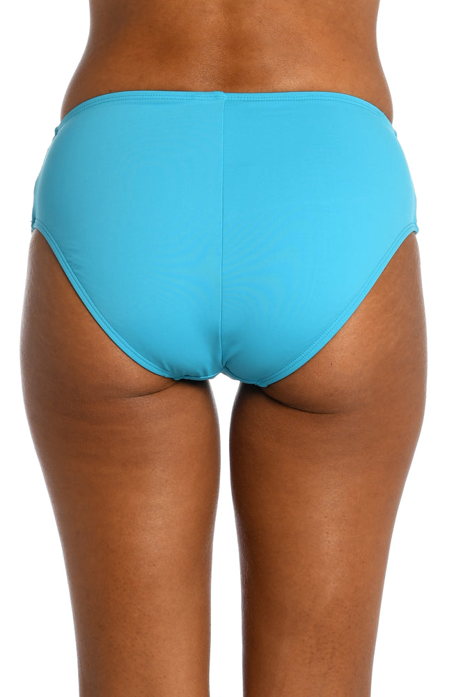 
            
                Load image into Gallery viewer, Model is wearing a azul (light blue) colored mid-waist swimsuit bottom from our Best-Selling Island Goddess collection.
            
        
