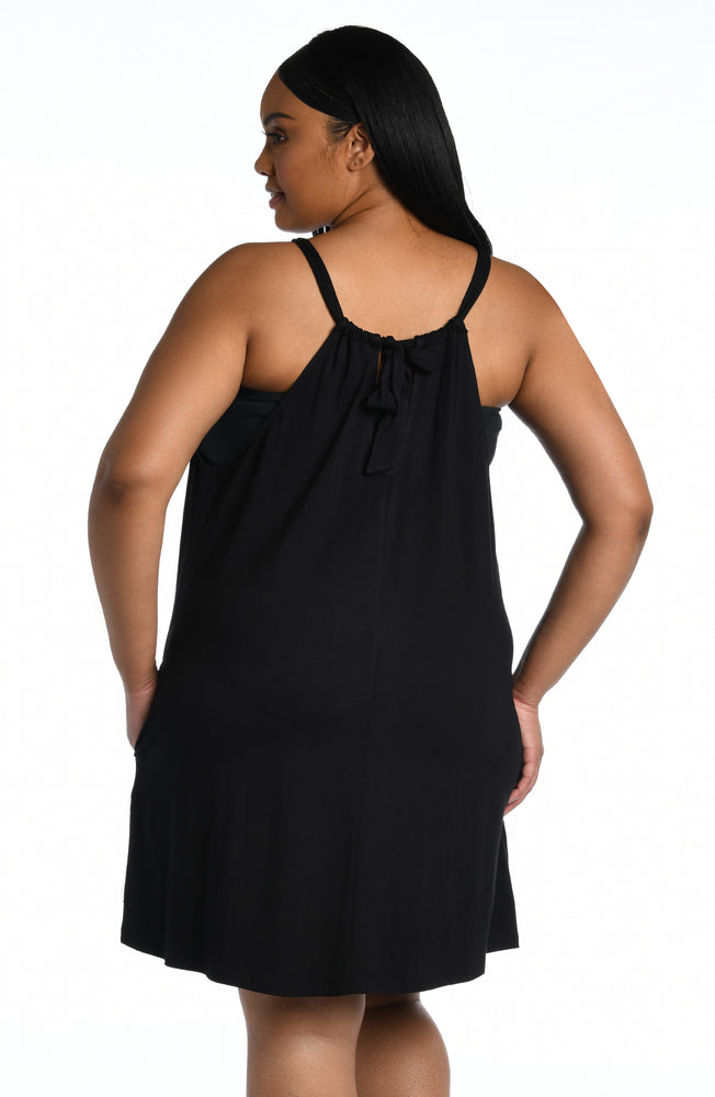 Model is wearing a black mini dress swimsuit cover up from our Draped Darling collection.