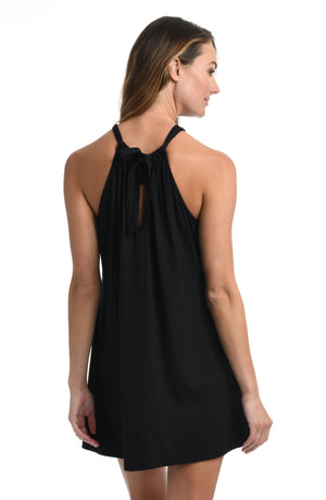 Model is wearing a black mini dress swimsuit cover up from our Draped Darling collection.