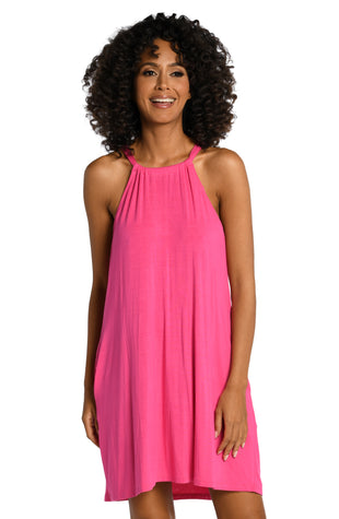 Model is wearing a pop pink colored high neck mini dress swimsuit cover up from our Draped Darling collection.