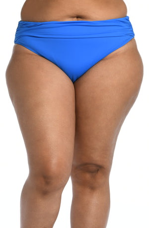 
            
                Load image into Gallery viewer, Model is wearing a capri blue colored shirred hipster swimsuit bottom from our Best-Selling Island Goddess collection.
            
        