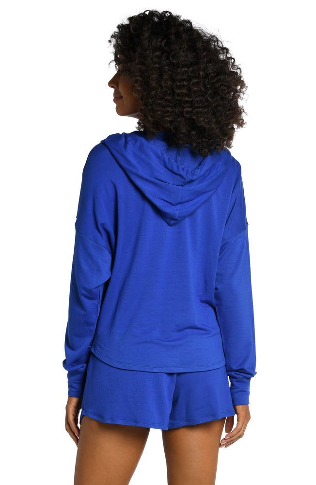 
            
                Load image into Gallery viewer, Model is wearing a sapphire colored hooded sweater from our Living in Leisure collection!
            
        