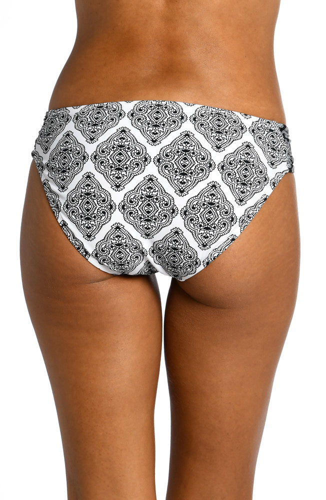Model is wearing a black and white geometric printed shirred hipster bottom from our Oasis Tile collection!