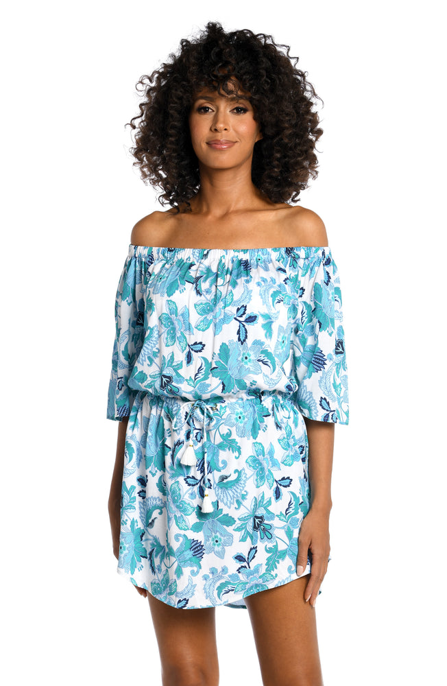 
            
                Load image into Gallery viewer, Model is wearing a light blue multi colored mediterranean printed off shoulder dress cover up from our Santorini Sun collection!
            
        