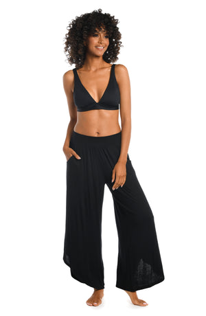 
            
                Load image into Gallery viewer, Model is wearing a black palazzo pant swimsuit cover up from our Draped Darling collection.
            
        