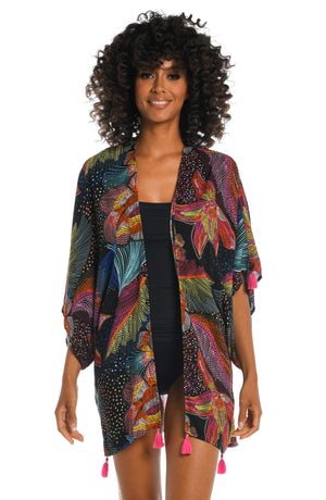 
            
                Load image into Gallery viewer, Model is wearing a shiny multicolored tropical printed kimono cover up from our Sunlit Soriee collection!
            
        