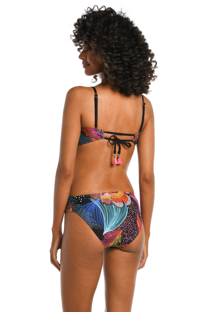 
            
                Load image into Gallery viewer, Model is wearing a shiny multicolored tropical printed bandeau top from our Sunlit Soriee collection!
            
        
