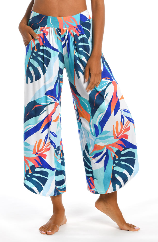 
            
                Load image into Gallery viewer, Model is wearing a blue multi colored tropical printed cover up pant from our Coastal Palms collection!
            
        