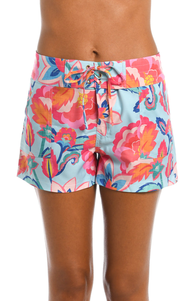 Model is wearing a light blue multi colored tropical printed board short bottom from our Breezy Beauty collection!