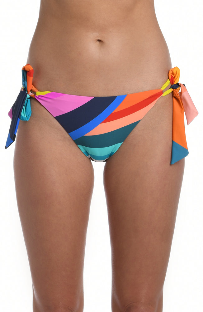 Model is wearing multi colored vibrant geometric printed side tie hipster bottom from our Sunscape collection!