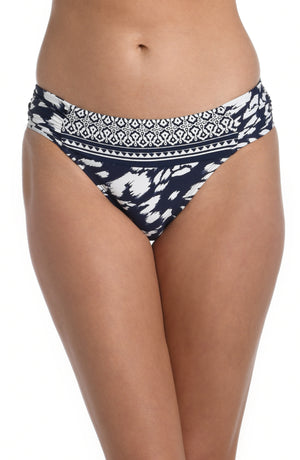 
            
                Load image into Gallery viewer, Model is wearing a indigo blue colored print with pops of white on this side shirred hipster bottom from our Changing Tides collection!
            
        