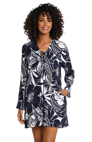 
            
                Load image into Gallery viewer, Model is wearing an indigo colored print with pops of white on this v-neck tunic cover up from our At the Playa collection!
            
        