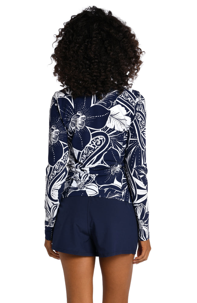 
            
                Load image into Gallery viewer, Model is wearing an indigo colored print with pops of white on this half zip rashguard top from our At the Playa collection!
            
        