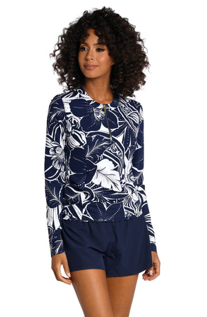 
            
                Load image into Gallery viewer, Model is wearing an indigo colored print with pops of white on this half zip rashguard top from our At the Playa collection!
            
        
