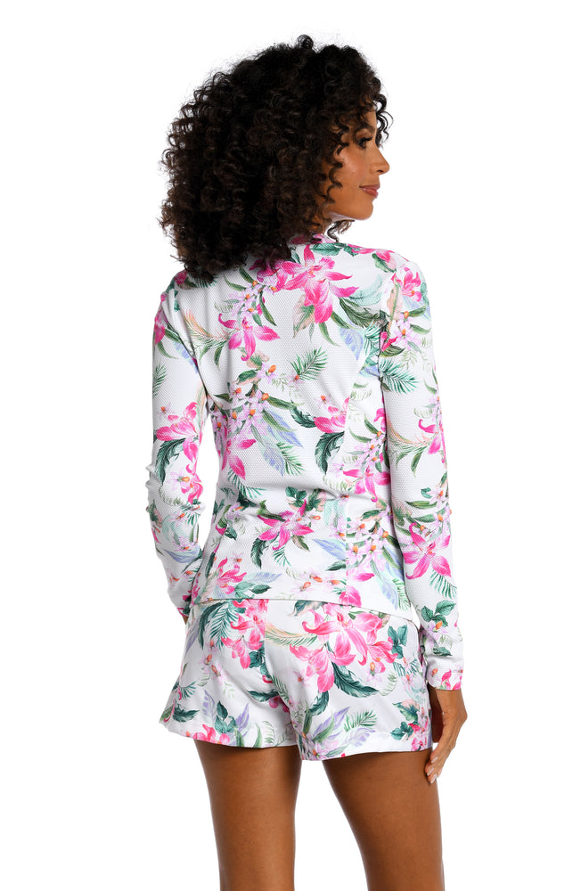 
            
                Load image into Gallery viewer, Model is wearing multi colored tropical print on a white backround with this half zip rashguard top from our Mystic Palms collection!
            
        