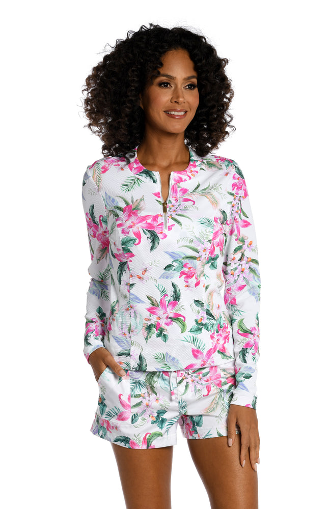 
            
                Load image into Gallery viewer, Model is wearing multi colored tropical print on a white backround with this half zip rashguard top from our Mystic Palms collection!
            
        