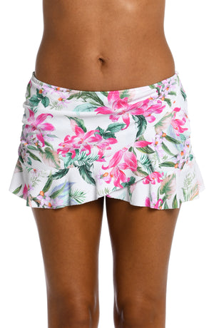 
            
                Load image into Gallery viewer, Model is wearing multi colored tropical print on a white backround with this asymmetrical ruffle skirted bottom from our Mystic Palms collection!
            
        