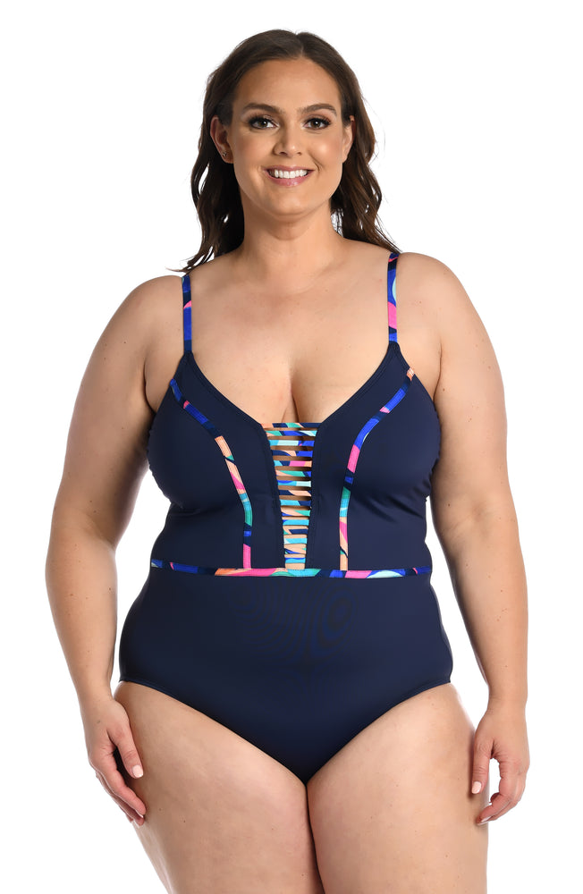 
            
                Load image into Gallery viewer, Model is wearing a bold paint-like stroke of vibrant dark colors printed on this plunge one piece from our Painted Leaves collection!
            
        