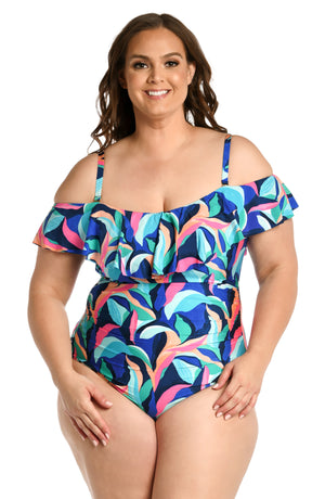 Model is wearing a bold paint-like stroke of vibrant dark colors printed on this off shoulder ruffle one piece from our Painted Leaves collection!