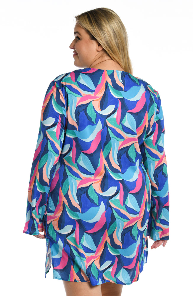 Model is wearing a bold paint-like stroke of vibrant dark colors printed on this v-neck tunic cover up from our Painted Leaves collection!