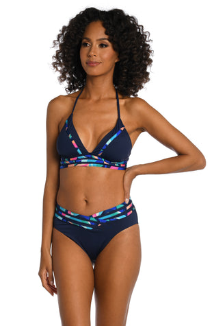 Model is wearing a bold paint-like stroke of vibrant dark colors printed on this banded halter top from our Painted Leaves collection!