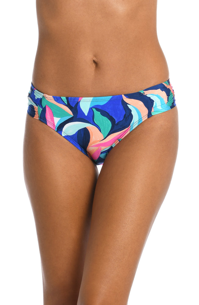 Model is wearing a bold paint-like stroke of vibrant dark colors printed on this side shirred hipster bottom from our Painted Leaves collection!
