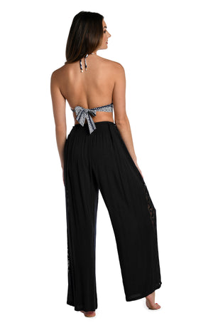 
            
                Load image into Gallery viewer, Model is wearing a crochet detailed pattern on this black palazzo pant cover up from out Coastal Covers collection!
            
        