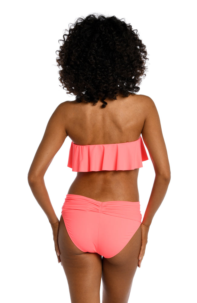 Model is wearing a hot coral colored ruffle bandeau swimsuit top from our Best-Selling Island Goddess collection.