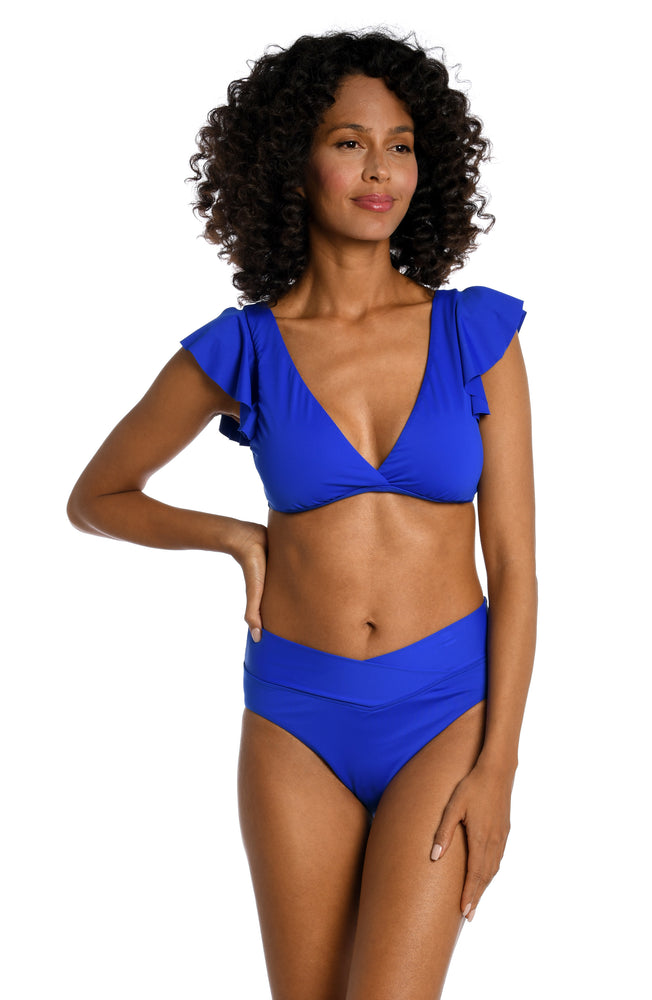 Model is wearing a sapphire colored ruffle sleeve swimsuit top from our Best-Selling Island Goddess collection.