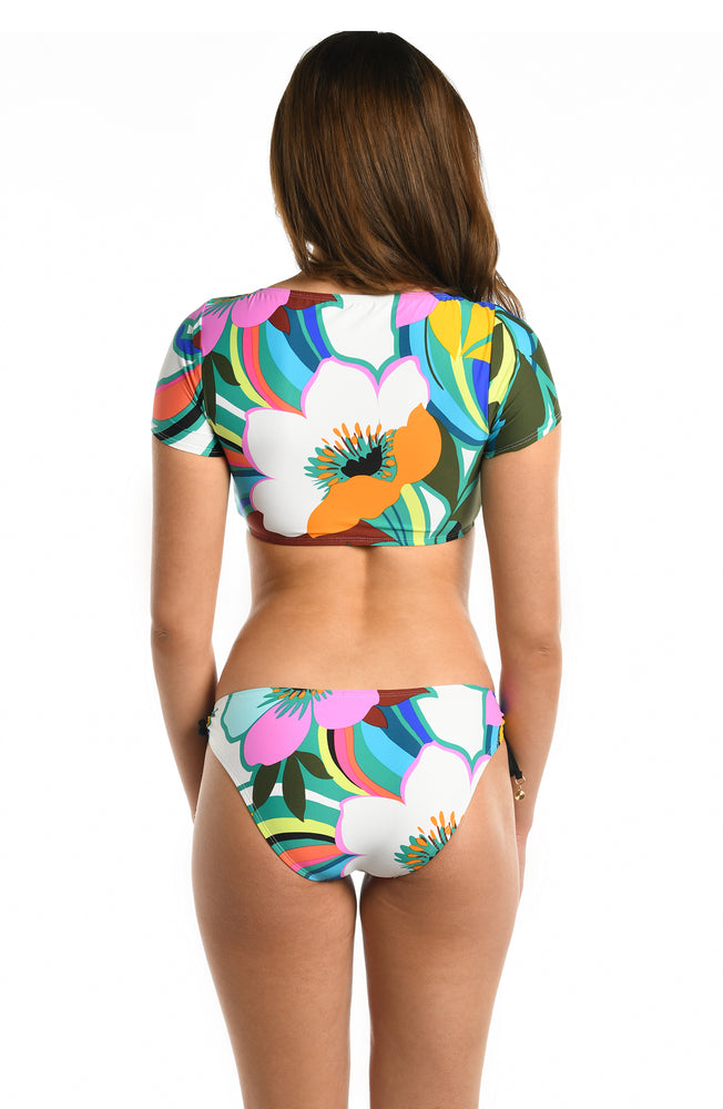 Model is wearing a multicolored bold floral printed cap sleeve bikini top from our Sun Catcher collection. 