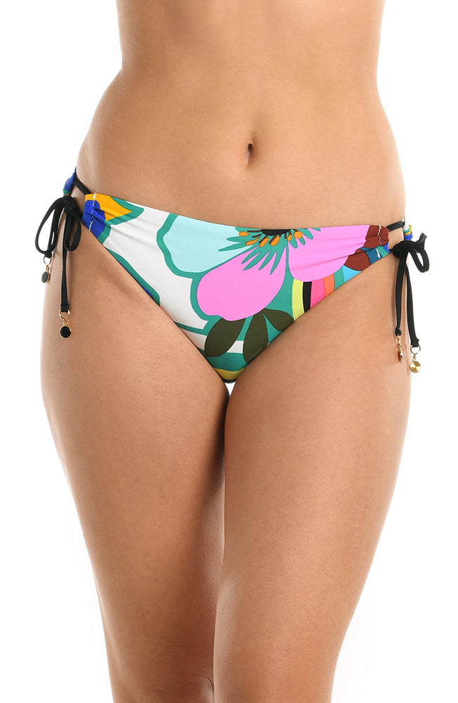 Model is wearing a multicolored bold floral printed side tie hipster bikini bottom from our Sun Catcher collection. 
