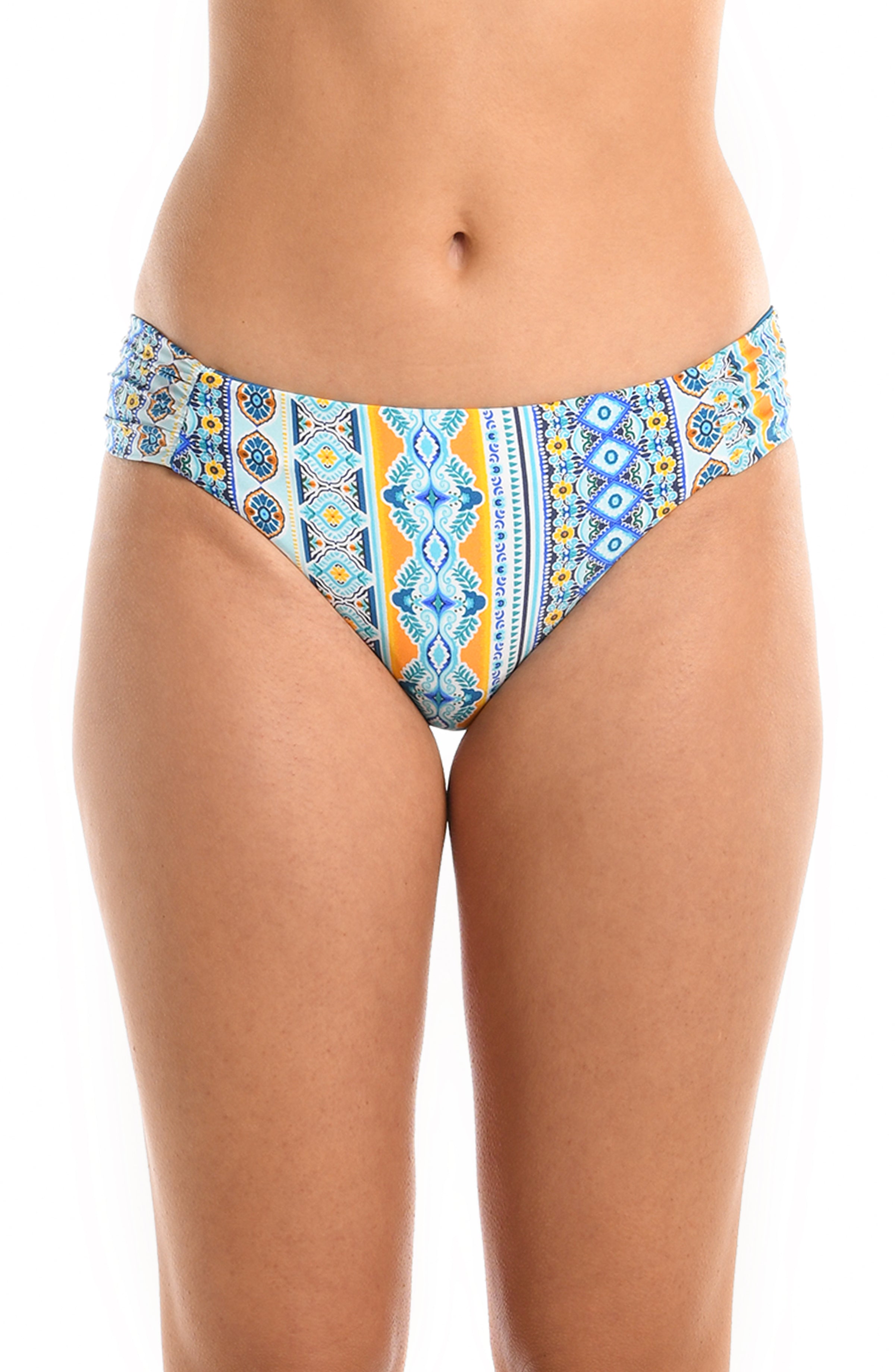 Model is wearing a blue multicolored mediterranean printed reversible side shirred hipster bikini bottom from our Scarf City collection.