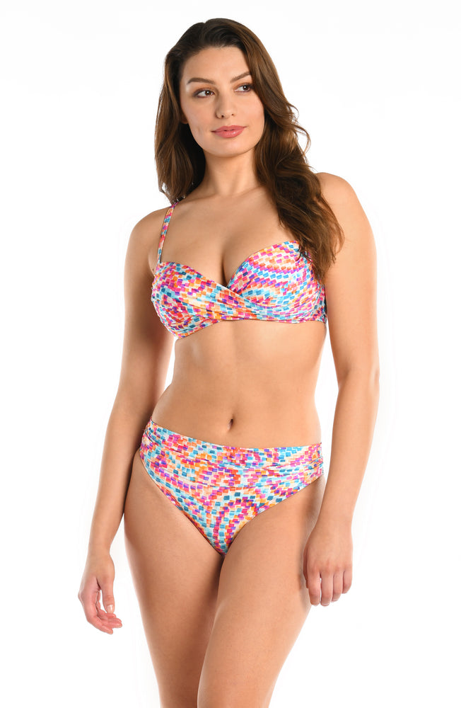 Model is wearing a pink multicolored paisley printed over the shoulder wrap front bikini top from our Pebble Beach collection.