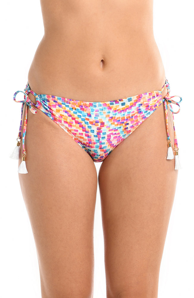 Model is wearing a pink multicolored paisley printed side tie hipster bikini bottom from our Pebble Beach collection.