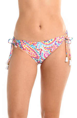 Model is wearing a pink multicolored paisley printed side tie hipster bikini bottom from our Pebble Beach collection.