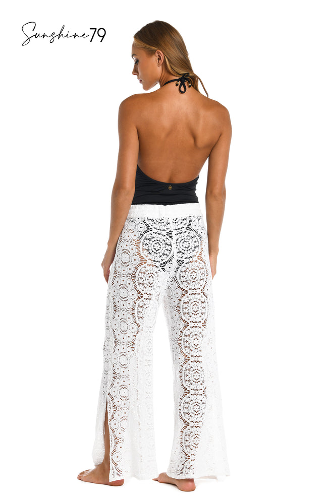 
            
                Load image into Gallery viewer, Model is wearing a white crochet beach pant cover up from our Sunshine 79 brand. 
            
        