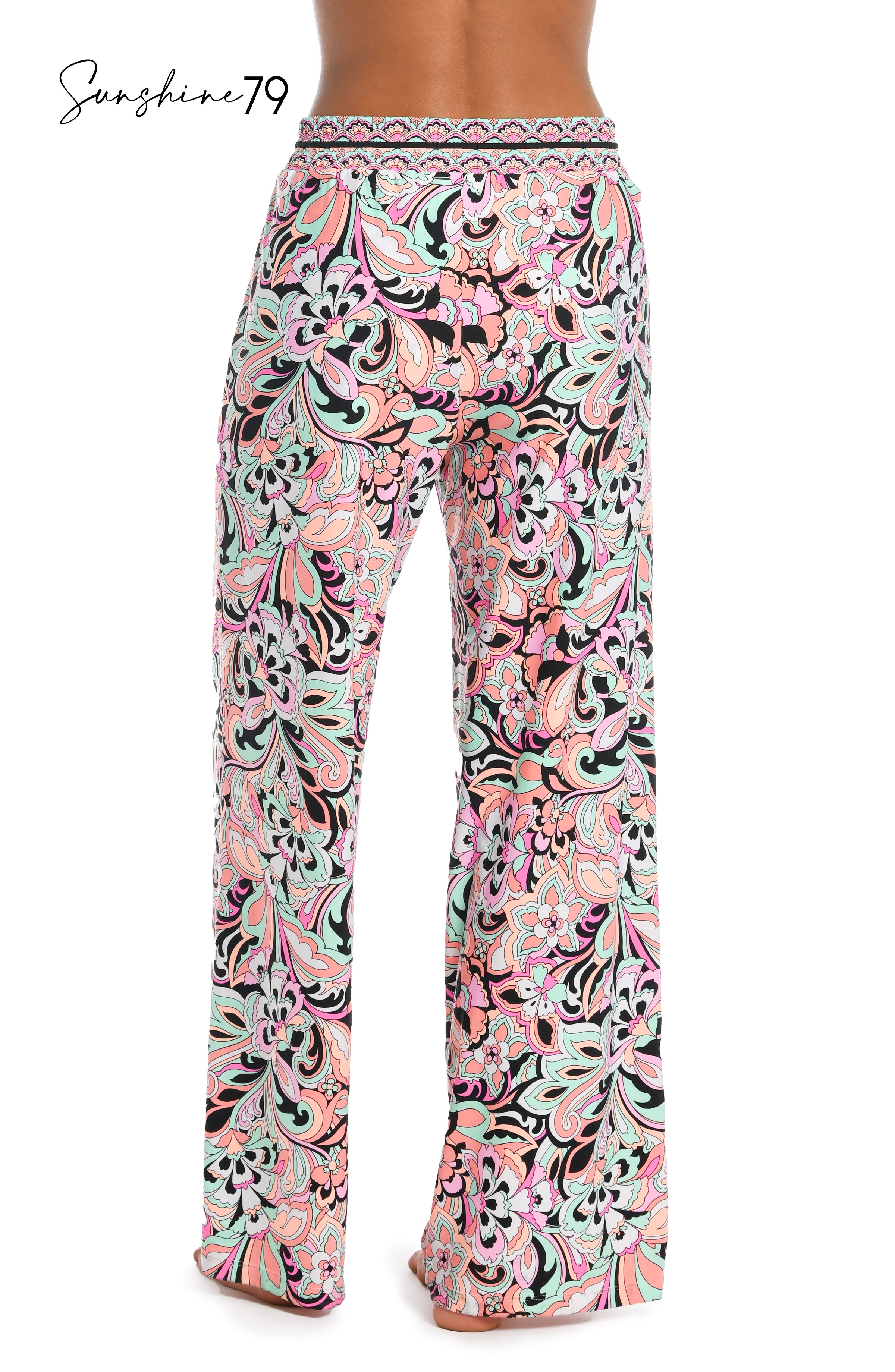 Model is wearing a pink multicolored paisley printed beach pant cover up from our Sunshine 79 brand.