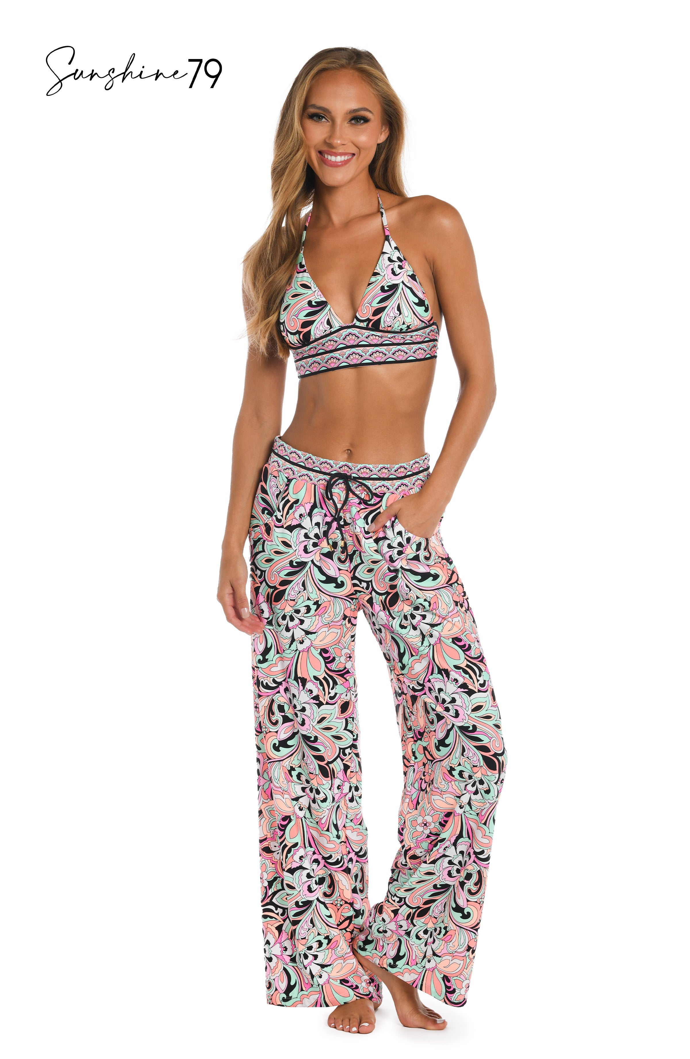 Model is wearing a pink multicolored paisley printed beach pant cover up from our Sunshine 79 brand.