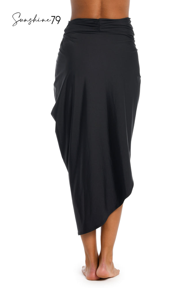 Model is wearing a solid black pull on faux pareo cover up wrap from our Sunshine 79 brand.