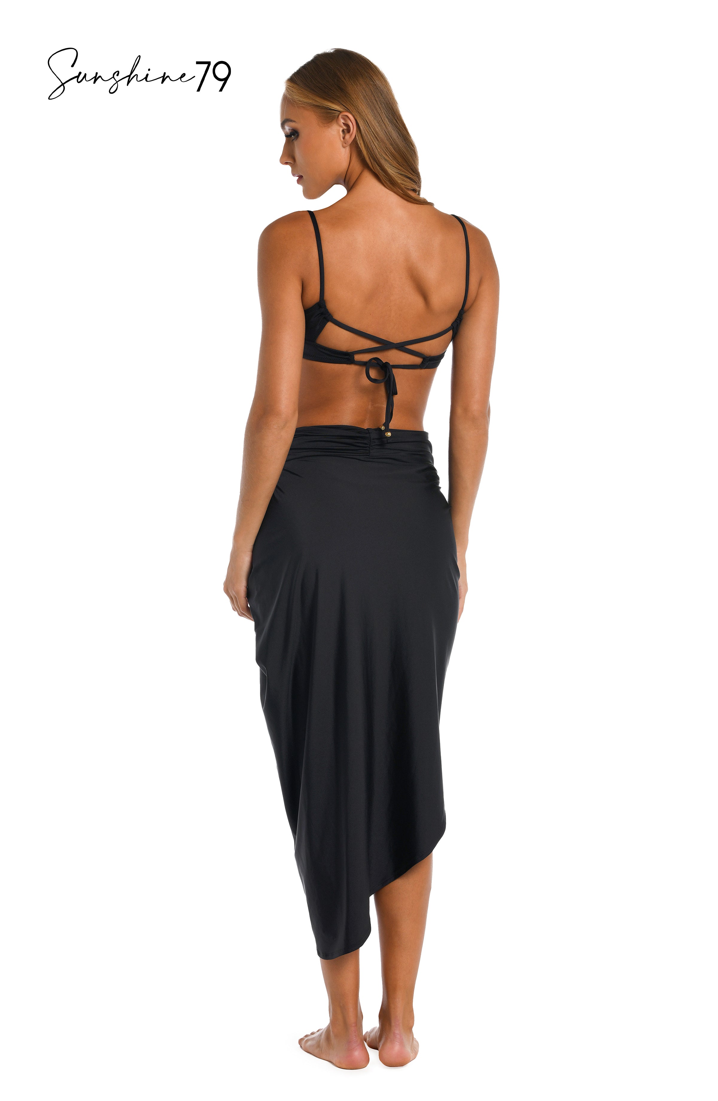 Model is wearing a solid black pull on faux pareo cover up wrap from our Sunshine 79 brand.